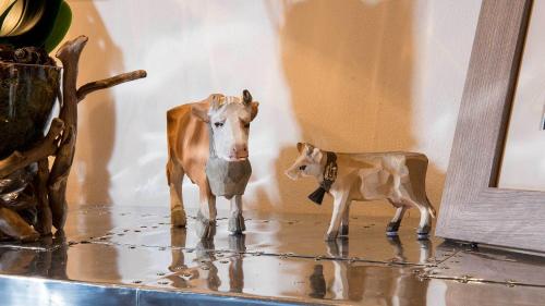 two figurines of a cow and a calf on a table at Hotel Olden in Gstaad