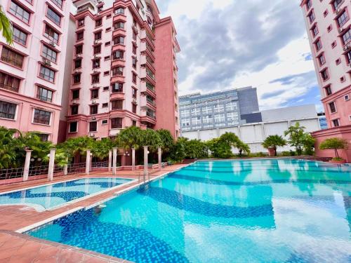 a large swimming pool in the middle of two tall buildings at Ber-Santai at Marina Court in Kota Kinabalu