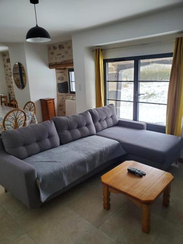 un salon avec un canapé et une table dans l'établissement Relais du lac de la Truyère, à Anglards-de-Saint-Flour