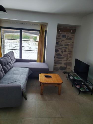 un salon avec un canapé et une table basse dans l'établissement Relais du lac de la Truyère, à Anglards-de-Saint-Flour