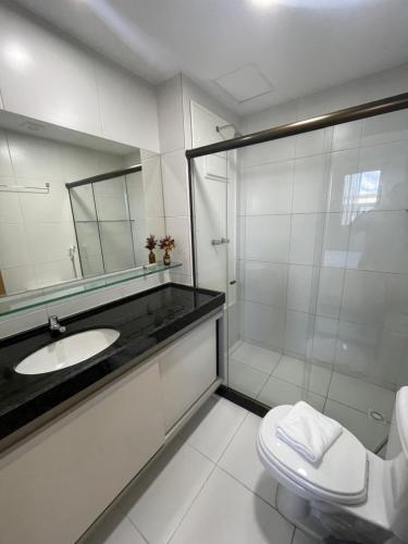 een badkamer met een douche, een wastafel en een toilet bij Flat com vista para piscina principal in Ipojuca