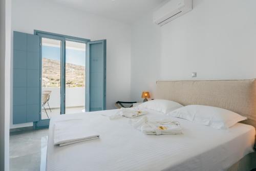 a bedroom with a white bed with towels on it at Orion Suite & Apartments in Donoussa