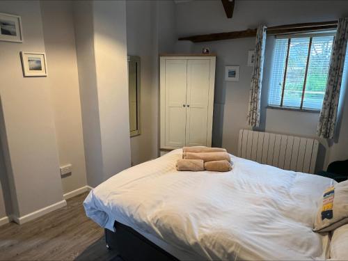 a bedroom with a bed with two towels on it at Beech Cottage in Ilfracombe