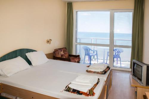 a bedroom with a bed with a view of the ocean at Hotel Kremikovci in Kiten
