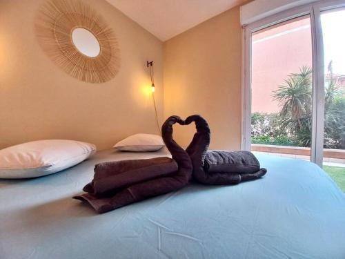 un cygne fait de serviettes assises sur un lit dans l'établissement Port Fréjus - Tout à pied - WIFI - Clim, à Fréjus