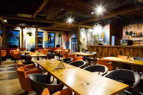 ヴジェシニャにあるHotel Węgierkiの木製のテーブルと椅子が備わる空きレストランです。