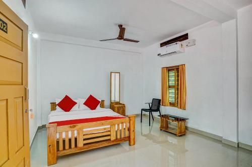 - une chambre avec un lit doté d'oreillers rouges dans l'établissement Flagship Thottunkal Building Thodupuzha, à Neriyamangalam