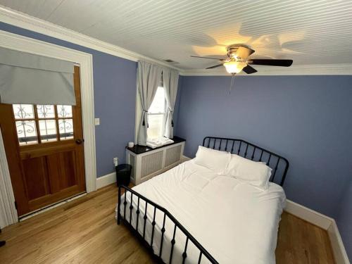 ein blaues Schlafzimmer mit einem Bett und einem Deckenventilator in der Unterkunft Stupendous Apartment Steps From the Capitol! in Washington