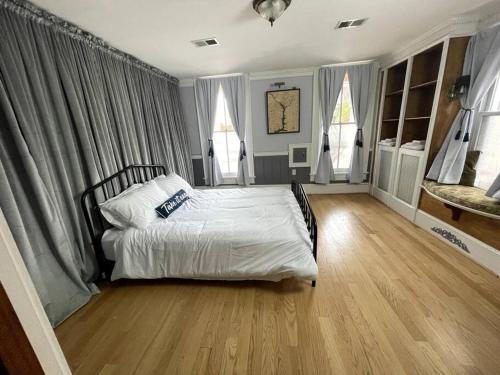 1 Schlafzimmer mit einem Bett mit weißer Bettwäsche und 2 Fenstern in der Unterkunft Stupendous Apartment Steps From the Capitol! in Washington