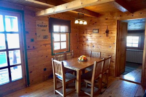 ein hölzernes Esszimmer mit einem Holztisch und Stühlen in der Unterkunft Guest House Montana in Kopaonik