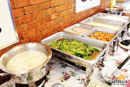 a counter with trays of food on a table at The Castello Resort in Ko Larn