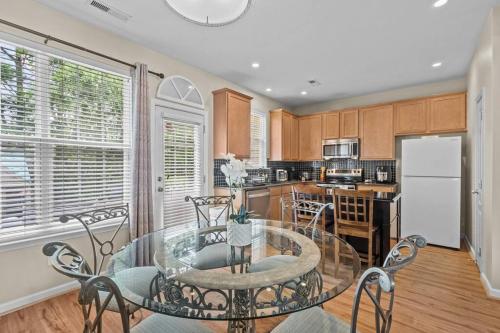 a kitchen with a glass table and chairs and a refrigerator at Peaceful, townhome in Hope Valley Farms in Durham