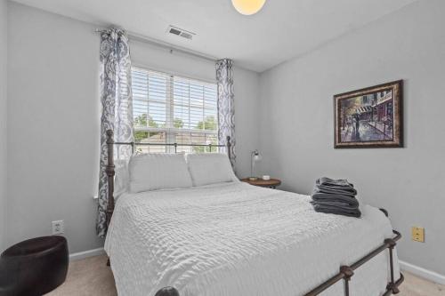 ein Schlafzimmer mit einem Bett und einem Stuhl und einem Fenster in der Unterkunft Peaceful, townhome in Hope Valley Farms in Durham