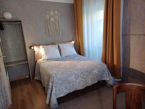 um pequeno quarto com uma cama e uma janela em Chambresdhoteslaforet com em Longwy