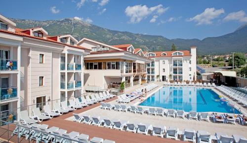 Blick auf ein Hotel mit Pool und Stühlen in der Unterkunft Aes Club Hotel in Oludeniz