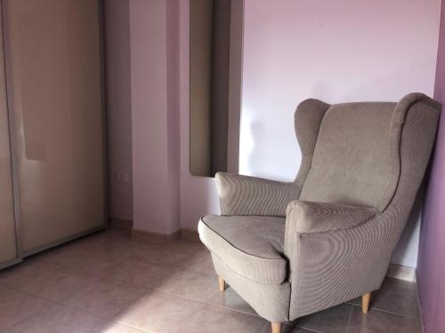 einem grauen Stuhl in einem Raum neben einem Fenster in der Unterkunft Casa Vacanze 365 - blu in Tortoreto Lido
