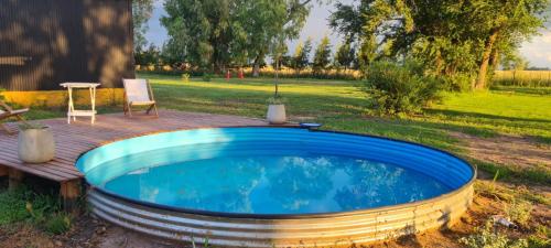 a hot tub in a backyard with a table and a chair at La Angelita Oeste in San Andrés de Giles