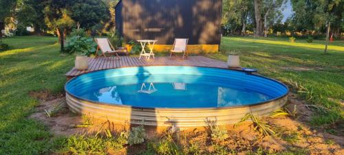 een zwembad in de tuin met 2 stoelen en een tafel bij La Angelita in San Andrés de Giles