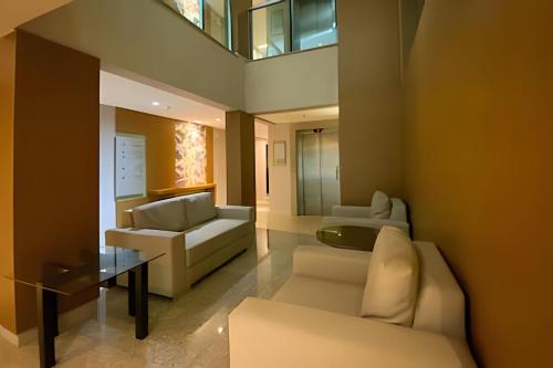 a living room with white furniture and a glass table at Hotel Brisas do Lago Brasília - Ozped Flats in Brasilia