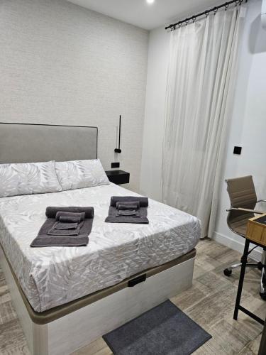 una camera da letto con un letto con due asciugamani sopra di Habitación céntrica de Lujo Gv 5 a Valencia