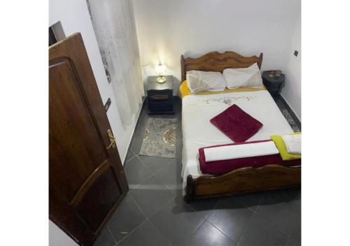 ein Schlafzimmer mit einem Bett mit einem Holzrahmen in der Unterkunft Apartment in Safi Fantastic Near the sea, Morocco in Safi
