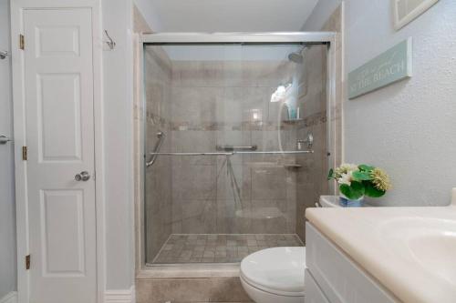 a bathroom with a shower with a toilet and a sink at Baca Beach Escape I - 3 Pools - Pet Friendly in Galveston