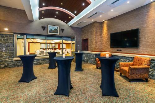 a lobby with black stools and a tv at Royal Canadian Lodge in Banff