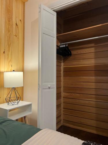 a bedroom with a closet with a bed and a lamp at Chalet 86 - 3 Minutes From Whiteface Mountain in Wilmington