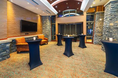 a hotel lobby with stools and a tv at Royal Canadian Lodge in Banff
