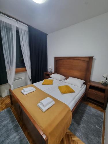 a bedroom with a large bed with two towels on it at Hotel Paviljon in Bihać