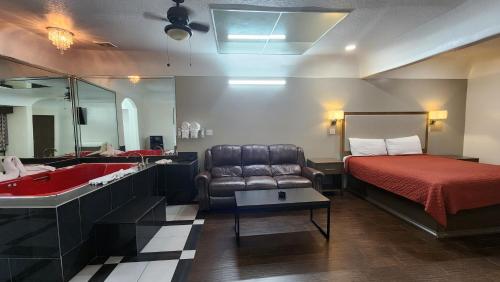 ヒューストンにあるScottish Inn & Suites Sam Houston Parkwayのベッド、ソファ、シンクが備わるホテルルームです。