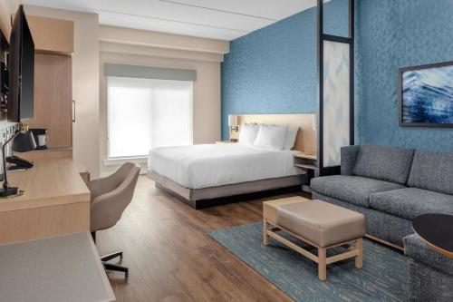 a hotel room with a bed and a couch at Hyatt Place St Augustine Vilano Beach in Saint Augustine