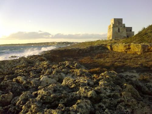 a castle on a cliff next to the ocean at Residence Atlante in Leporano
