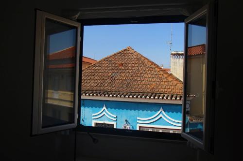 ein Fenster mit Blick auf ein Gebäude mit Fliesenboden in der Unterkunft Inncork Guesthouse in Ponte de Sor