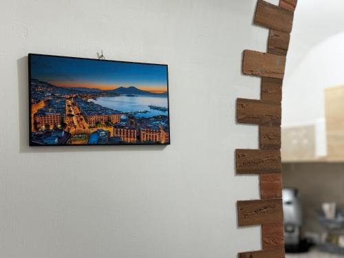 einen Flachbild-TV, der an einer Wand hängt in der Unterkunft Amaré Guest House in Neapel