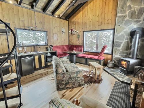 a living room with a fireplace and a stone stove at Ranch de Frisons le Fer à Cheval - Le Madison - Chalet Rustchic au pied du Mont Mégantic in La Patrie