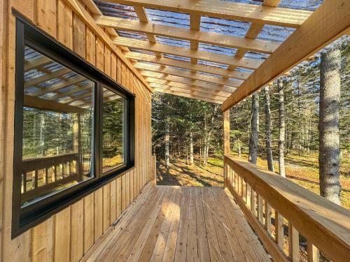 a porch of a wooden house with a window at Chalet Le Madison Refuge nordique et ciel étoilé au pied du Mont-Mégantic in La Patrie
