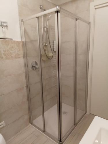 La salle de bains est pourvue d'une douche avec une porte en verre. dans l'établissement Appartamento Milietta 2, à Monzambano