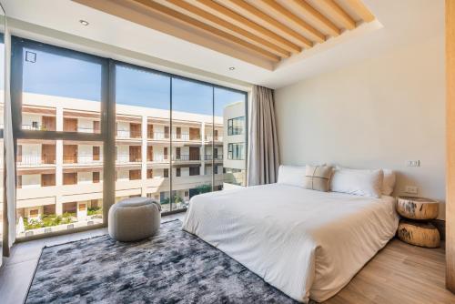 a bedroom with a bed and a large window at Hotel Faranda Single 1 Punta Cana - Adults Only in Punta Cana