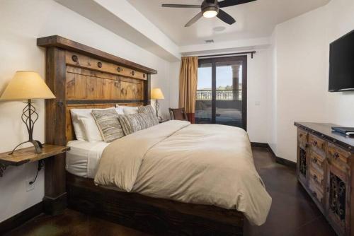 ein Schlafzimmer mit einem großen Bett mit einem hölzernen Kopfteil in der Unterkunft Luxury Downtown Rental (Hot Tub/Pet Friendly) - La Dolce Vita Villas #9 in Moab