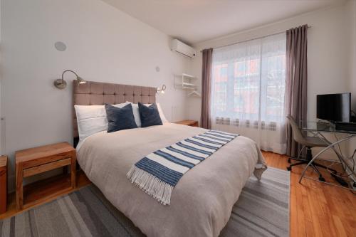 1 dormitorio con 1 cama grande y TV en Le Widor en Quebec