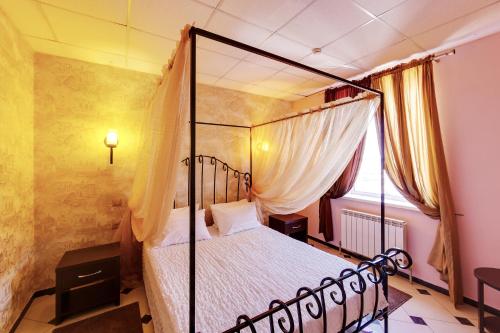 1 dormitorio con cama con dosel y ventana en Marton Turgeneva Krasnodar, en Krasnodar