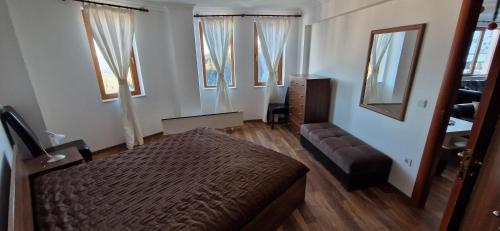 パンポロボにあるGrand Monastery 3 Apartment 10のベッドルーム1室(ベッド1台、ソファ、窓付)