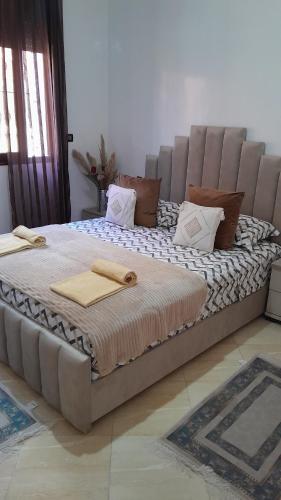 a large bed with two towels on top of it at Welcome Home in Beni Mellal