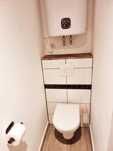 - une petite salle de bains avec des toilettes et un rouleau de papier toilette dans l'établissement Prestigieuse Résidence : N°14, à Bellac