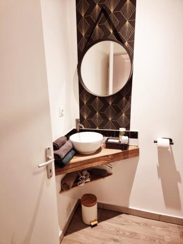 La salle de bains est pourvue d'un lavabo et d'un miroir. dans l'établissement Prestigieuse Résidence : N°14, à Bellac