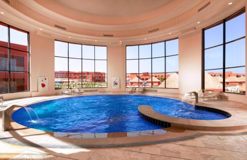 a large pool in a building with large windows at Pickalbatros Laguna Club Resort Sharm El Sheikh in Sharm El Sheikh