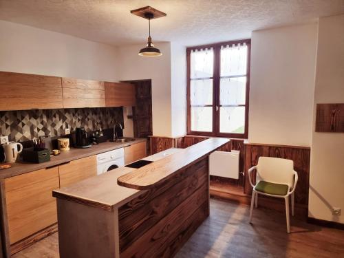 une cuisine avec des placards en bois et un grand îlot dans l'établissement Prestigieuse Résidence : N°14, à Bellac