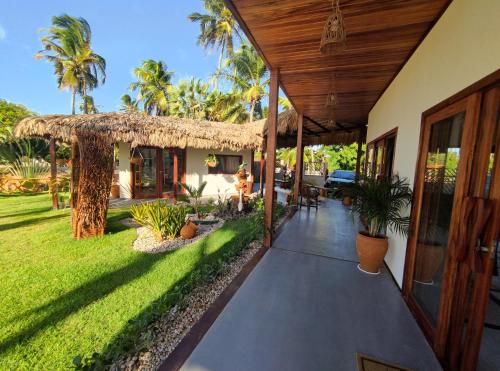 a porch of a house with a grass roof at Pousada Varanda Amar - Icaraizinho de Amontada in Icaraí