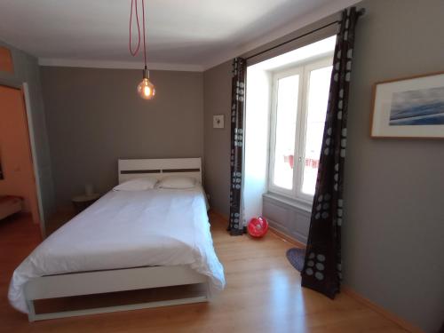 una camera da letto con un letto e una grande finestra di Tulle : bel appartement lumineux en centre ville a Tulle